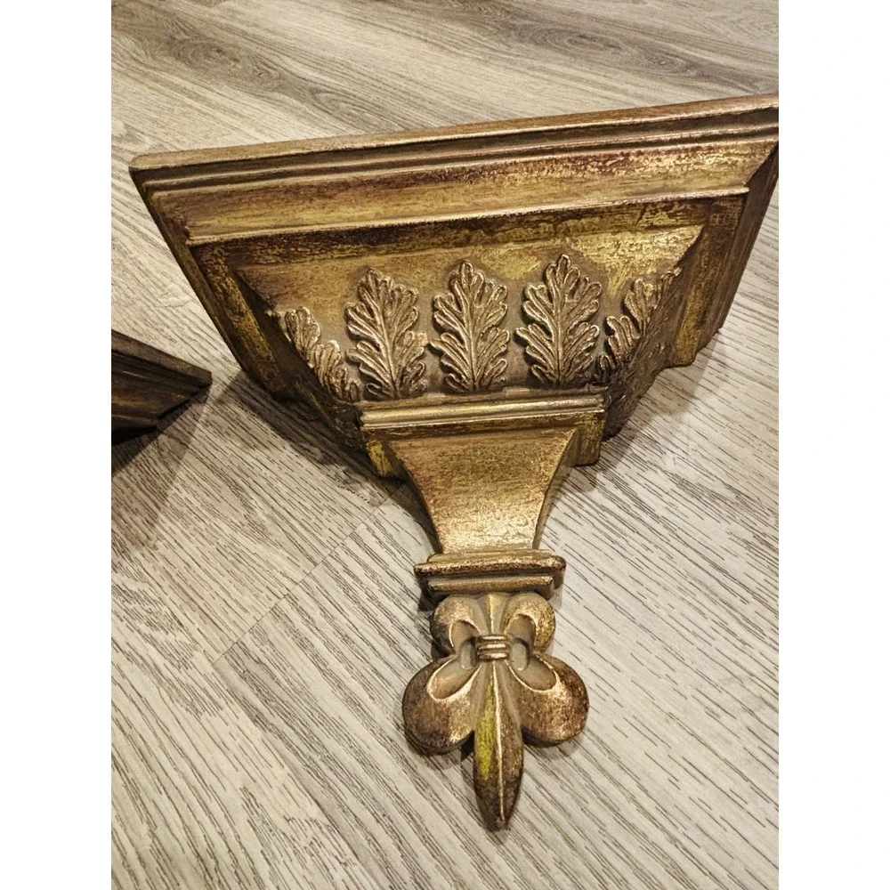 Vintage gold-toned decorative wall shelves with floral motifs.